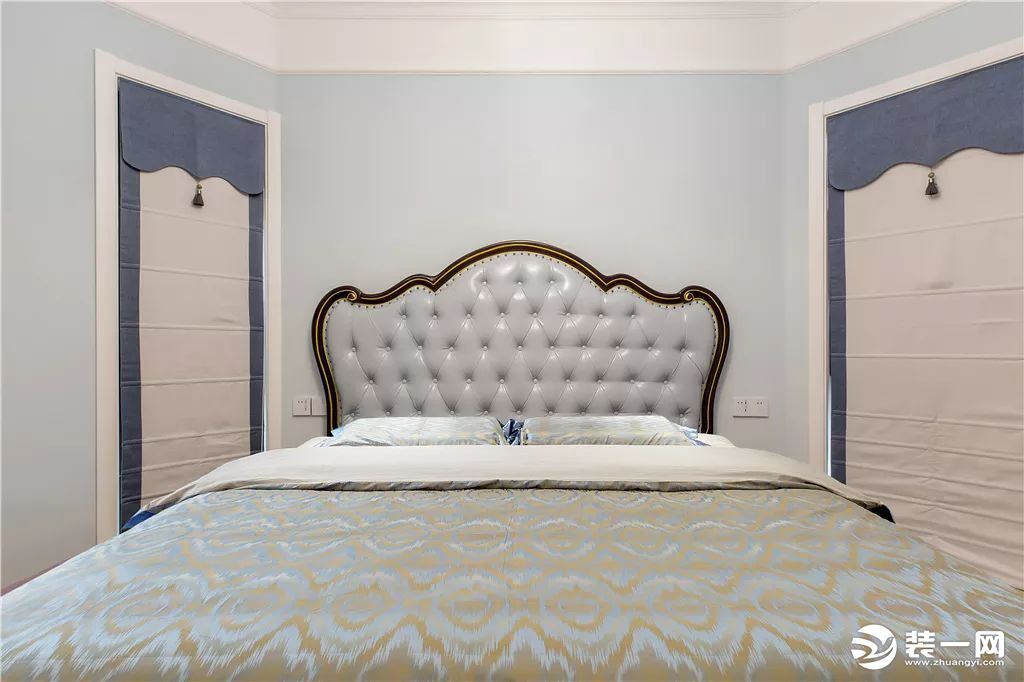设计师把床放在了两个窗户的中间，软包的床头靠背和床品给卧室带来了美式风的奢华感。