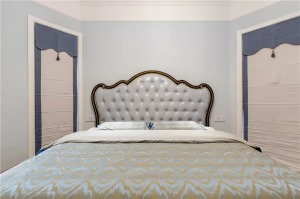設計師把床放在了兩個窗戶的中間，軟包的床頭靠背和床品給臥室帶來了美式風的奢華感。