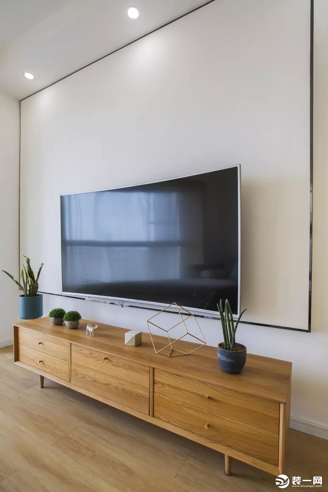 金边虎尾兰摆放在电视两旁，可以增加室内负离子浓度，净化空气，同时还能防辐射。木质矮柜，舒适大方。