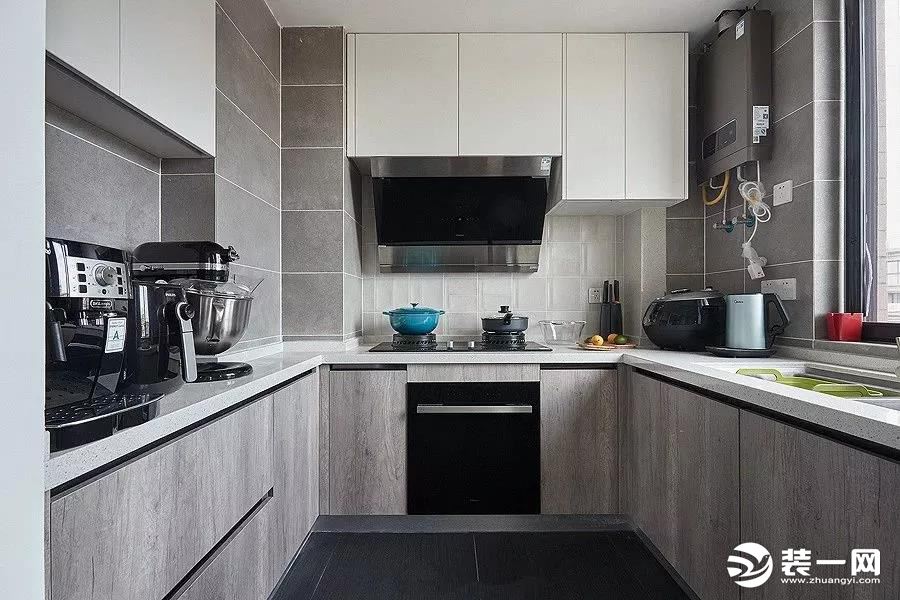 U型的厨房布局，深灰的地砖，浅灰的墙面，配合上白下灰的橱柜，不会压抑的同时显得高档整洁。