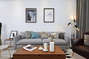 浅灰色的布艺沙发配上几何图案的抱枕、地毯，整体上舒适自然。木质茶几沉稳而有质感，充满情调的装饰摆件自