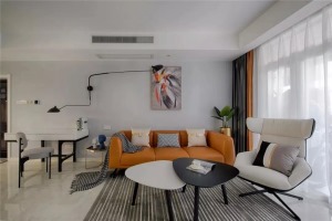 在入户门的另一侧就是客厅空间，灰蓝色的背景墙搭配简约的软装，亮橙色的皮沙发和窗帘给客厅增添了活力感