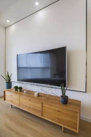 金边虎尾兰摆放在电视两旁，可以增加室内负离子浓度，净化空气，同时还能防辐射。木质矮柜，舒适大方。