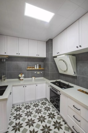 厨房灰色瓷砖搭配白色橱柜，简洁时尚。墙面上设置了木头隔板，方便收纳瓶瓶罐罐。