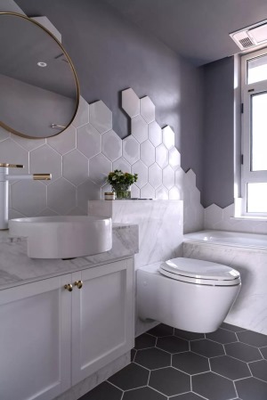 卫生间内的瓷砖铺贴非常有趣，地面是灰色的六边砖，墙面是白色的大理石六边砖和灰色漆的结合，还用浴缸来代