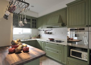厨房以墨绿色的橱柜再融合白色互相搭配，看起来整洁而又明亮，个性而不失大气