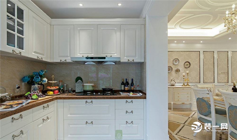 【厨房装修效果图】开放式的厨房实用而又美观，白色的一体柜搭配上银色的金属把手更显欧式风格。大理石面的