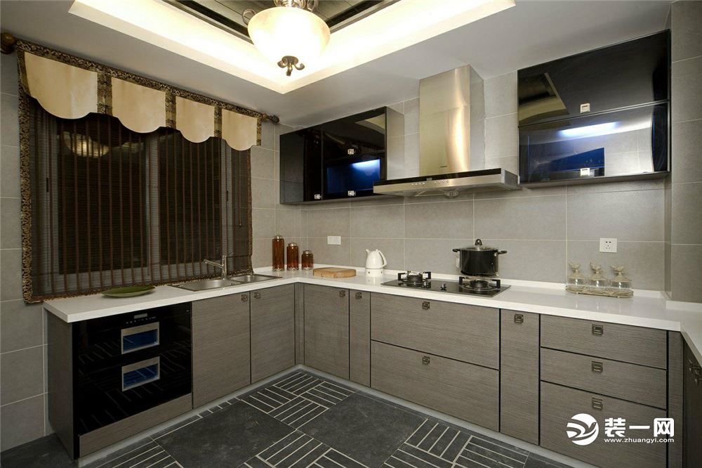 【厨房装修效果图】整体基调的厨房简单大气，一体柜搭配上钢质把手更加高端大气，灰色的背景墙面配上不锈钢