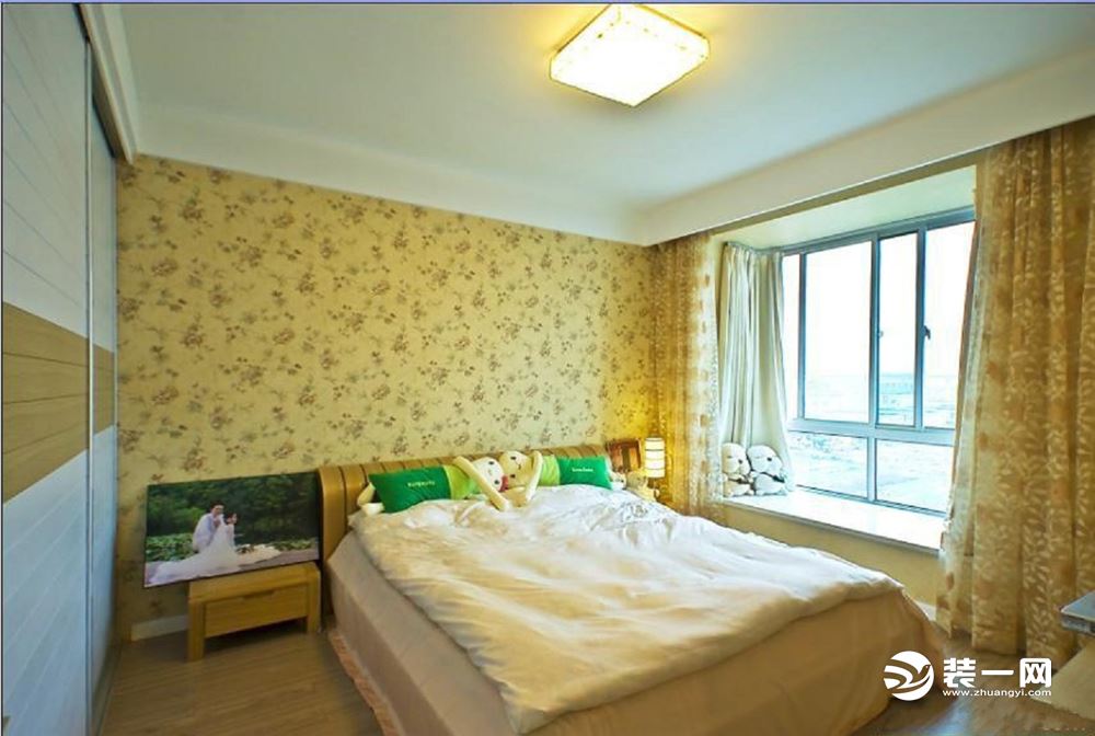 【卧室装修效果图】卧室墙面选用浅黄色翠花墙纸装饰，一进门就设计一个嵌入式的移门衣柜，空间的流畅性也不
