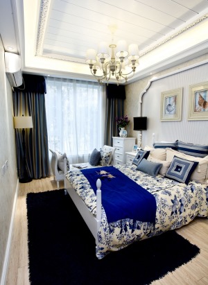 【卧室装修效果图】卧室延续了客餐厅的风格，白底蓝花纹的被单，深蓝色床尾布，让人眼前一亮。