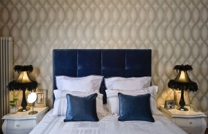 【次卧装修效果图】次卧在背景墙上做了一些改变，贴上金色花纹墙纸，延续客厅富丽的风格。