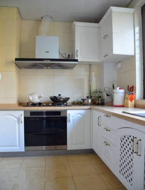 【厨房装修效果图】 白色的组合橱柜，简洁自然，橱柜上雕上花纹，非常符合田园风的风格。