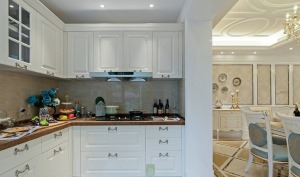 【厨房装修效果图】开放式的厨房实用而又美观，白色的一体柜搭配上银色的金属把手更显欧式风格。大理石面的