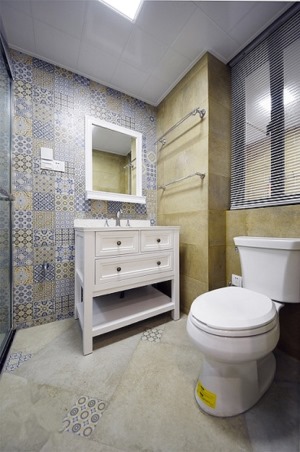 【卫生间装修效果图】卫生间的花砖墙壁是重要的装饰，配搭黄色瓷砖形成了一种协调，洗手台与储物柜一体化的