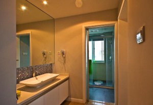 【卫生间装修效果图】洗手间的空间划分干湿分离，设计师利用大面积的镜子来增加空间感，结合灯光和马赛克点