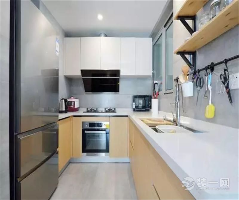 ▲ 厨房采光不佳，选用了灰色水泥砖铺贴地面和墙面，木色的橱柜，白色的台板和吊柜，简洁透亮空间，把冰箱
