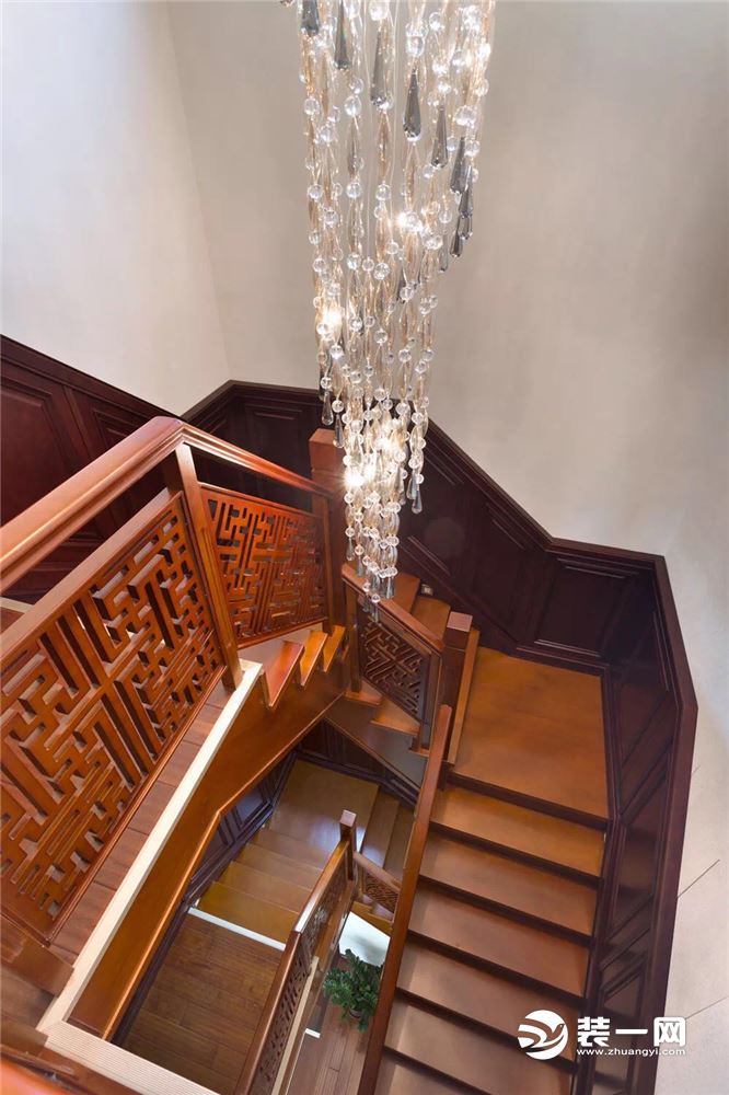 楼梯中间顶部装一款精致的水晶长吊灯，让这个高高的楼梯井显得不那么空档；