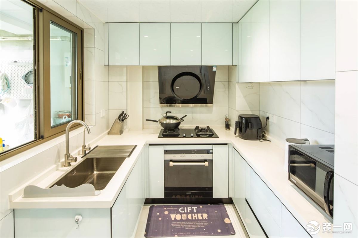 厨房U型的操作台空间，使得烹饪动线更加轻松，整体白色调的橱柜与墙面砖，让做饭空间显得明亮而又舒适。