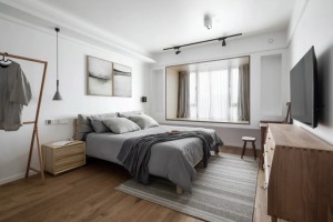 主人房整体空间都比较简洁舒适，床头墙上挂了两幅灰调的装饰画，搭配灰色地毯与床单布置，与木质感相呼应，