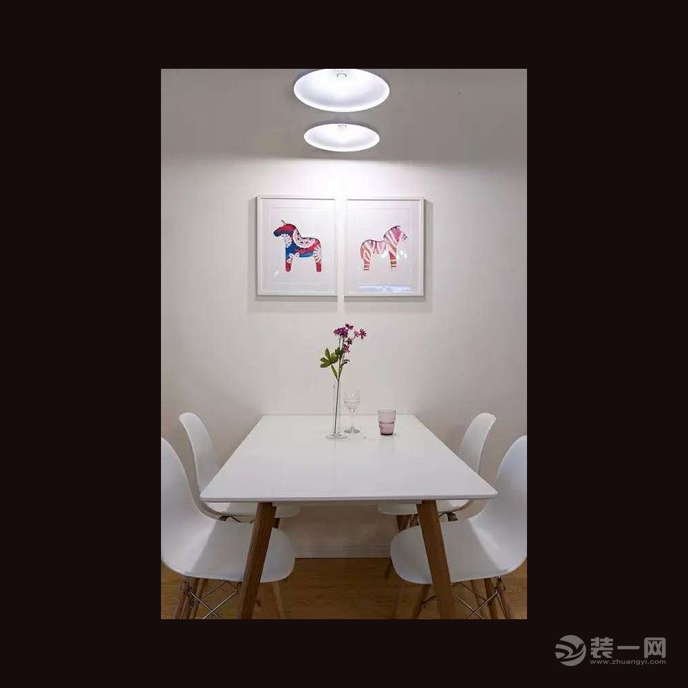 简单的餐厅，配色也很素雅。餐桌椅都选用白色的面和木质的腿，与白墙和木地板相呼应。墙上两幅可爱的彩色小