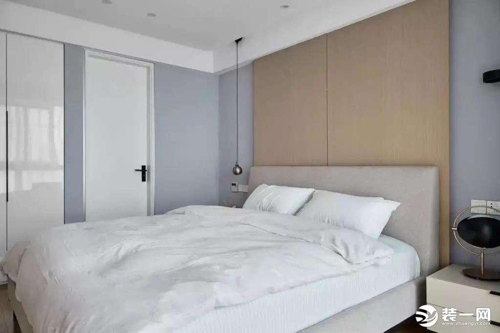 主卧，以木元素装饰床头背景，与客厅的电视背景墙相互呼应，白色的定制柜门线条利落整洁