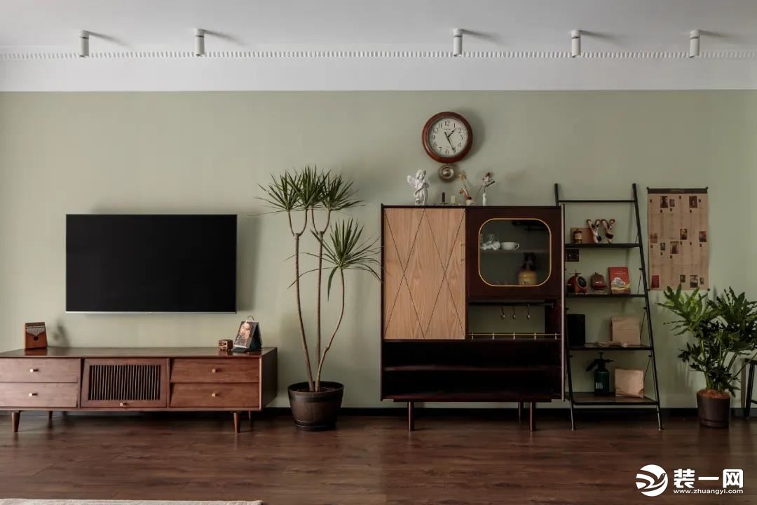电视背景区别于常规客厅的摆放形式，复古家具和植物错落排布以及不同纹理质感的木头进行混搭，承接了空间里