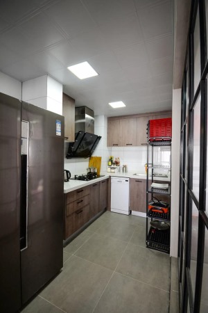 厨房，用黑框玻璃作为隔断让厨房光线变得更好，做旧款式的橱柜门和灰色地砖，让厨房多出了独特的韵味