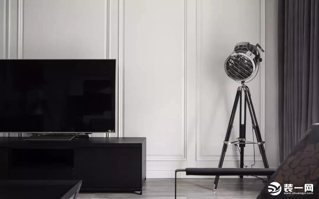 ▲ 电视背景运用一整面木饰面修饰，配合现代黑色电视柜