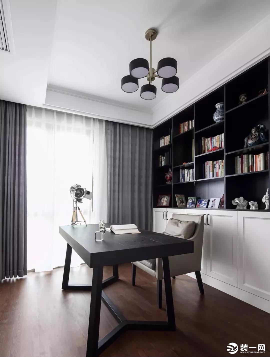 ▲ 书房整体延续灰白用色，简洁的书桌椅，黑白搭配的半开放式书柜作背景