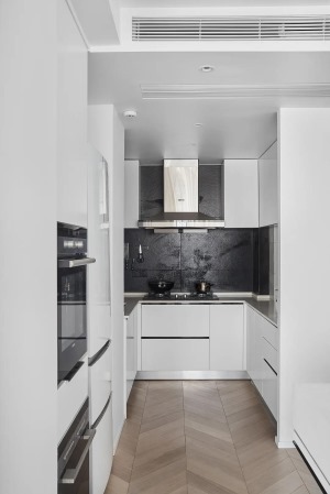 灰色台面和黑色墙砖与色柜门形成对比，为厨房增添冷静的质感，U型的橱柜充分利用了空间，让操作更加方便。