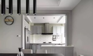 ▲ 厨房墙面工字铺白色地铁砖，灰色几何门板配黑色单颗拉手，橱柜台面延伸出早餐吧台