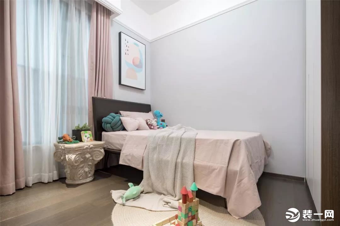 儿童房的窗帘和床品是选择了淡粉色的，设计师把床靠着墙角摆放，这样能够把活动空间集中，让孩子玩耍更加方