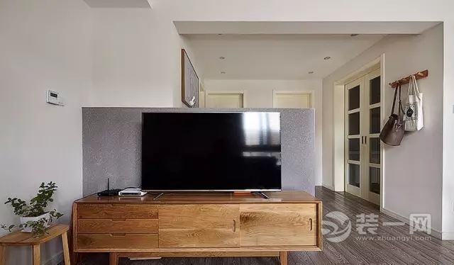 半截高度的电视背景墙设计，弥补了空间布局的不足，也让客厅更通透。