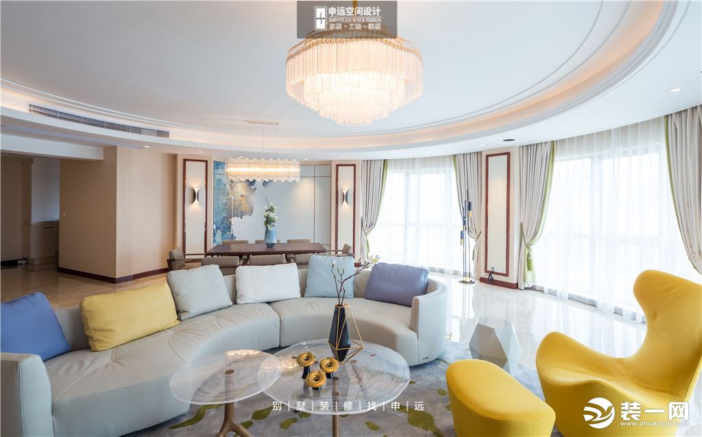 白色的弧形沙发贴合空间线条，配合简约的居家陈设品，使空间充满了清新的时尚气息。