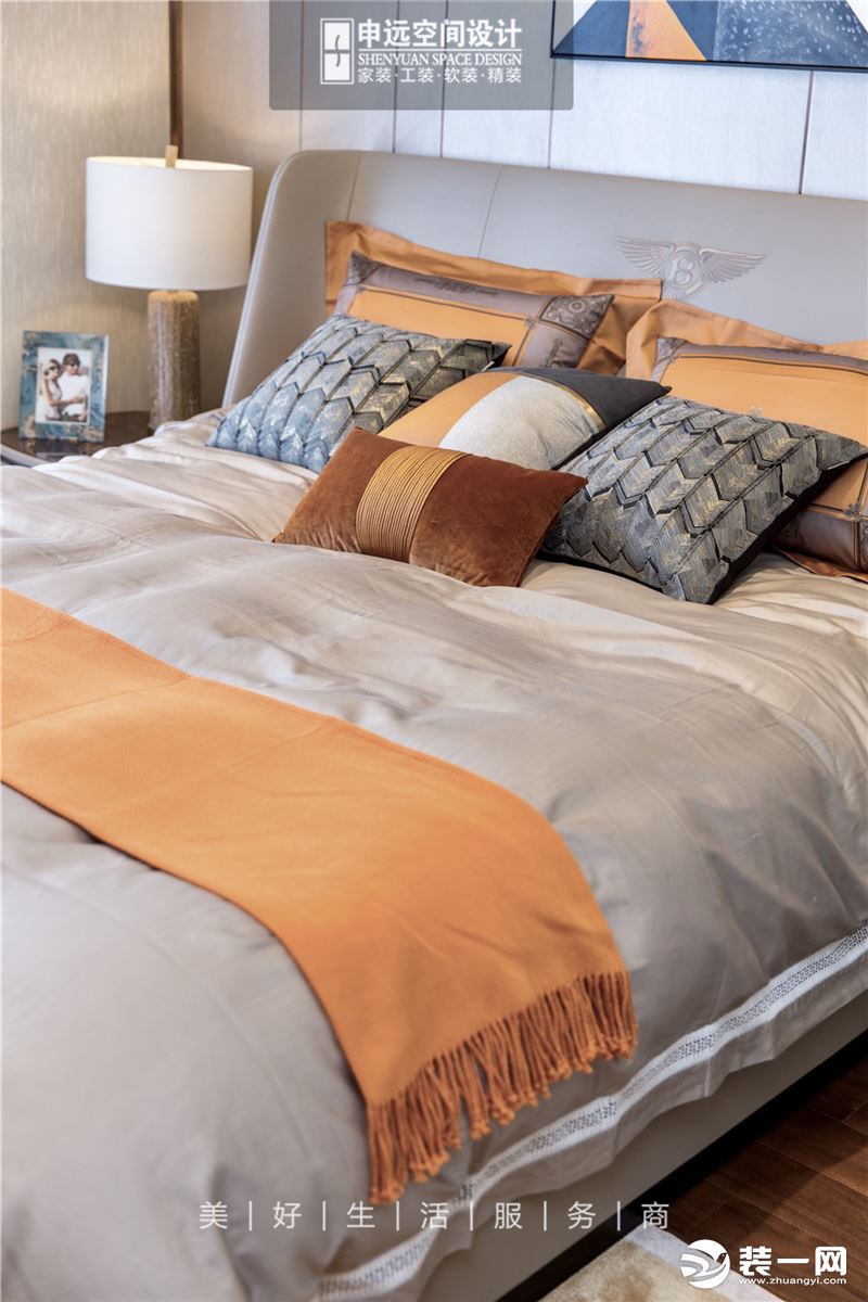床的主色为大象灰，被套等也选择与其相近的灰色，而枕头和床尾巾选用了橙色，包括窗帘也是酒红与灰色相拼