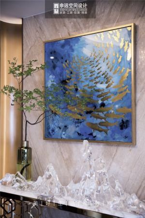 墙面上的装饰画，首次“点题”，鱼与水的描金油画采用玫瑰金色画框装裱，与下面的装饰台呼应。