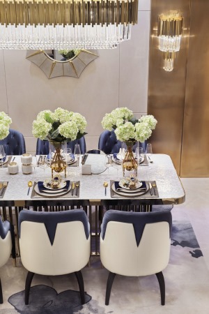 宝石蓝的丝绒座椅色泽低调内敛，造型古典而华美，设计线条柔和精致，弧线形的椅腿与直线型的餐桌支架相呼应