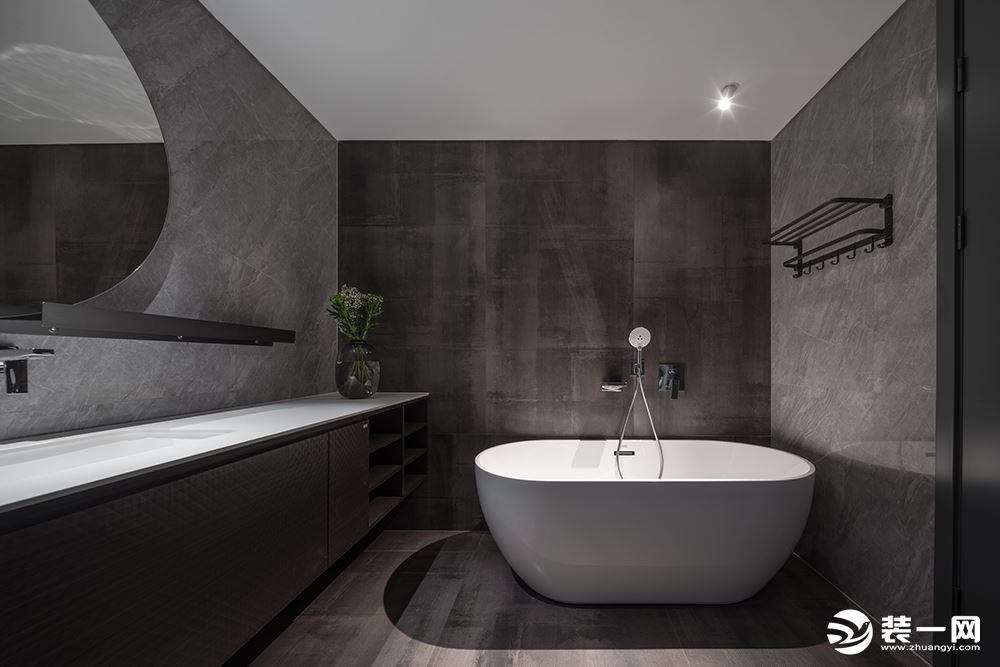 卫生间设置了独立的按摩浴缸，深色工业质感的墙地面，突显了主人的个性和品位。