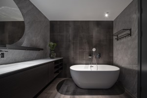 卫生间设置了独立的按摩浴缸，深色工业质感的墙地面，突显了主人的个性和品位。