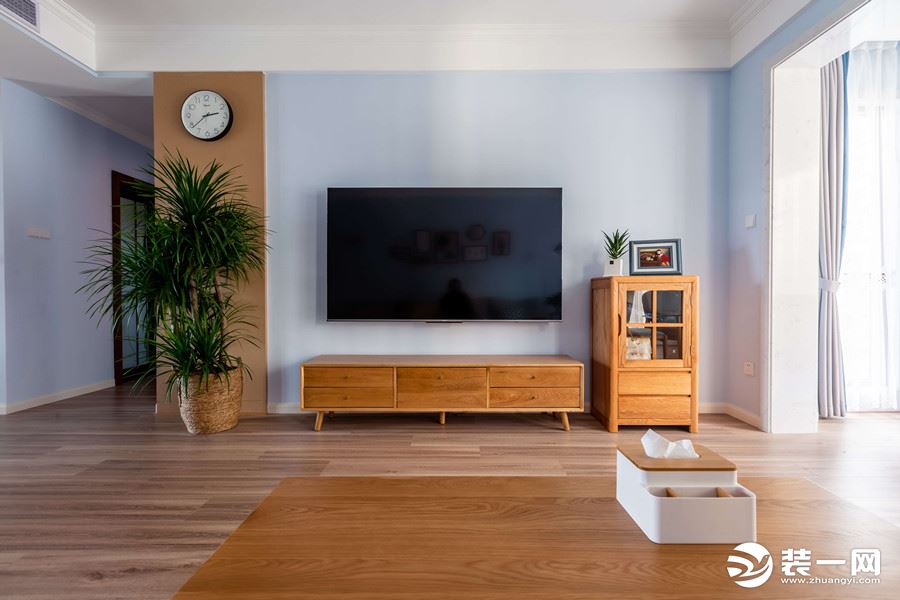 电视背景墙也是采用了淡蓝色，给人一种非常温馨的感觉，电视柜也是采用了木质的元素