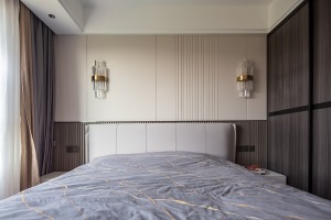 木色地板、灰色床组、奶白色纱帘、试管形组成的壁灯，在沉稳的色调和用材之下，撞色的床品在室内点缀，烘托