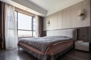 木色地板、灰色床组、奶白色纱帘、试管形组成的壁灯，在沉稳的色调和用材之下，撞色的床品在室内点缀，烘托