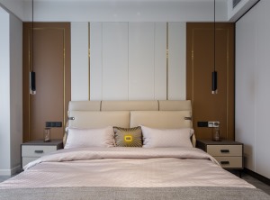 木色，白色和金色条线搭配的墙面让主卧更加惬意。床和床头柜的布置也最大限度地契合了户型，显得自然协调。