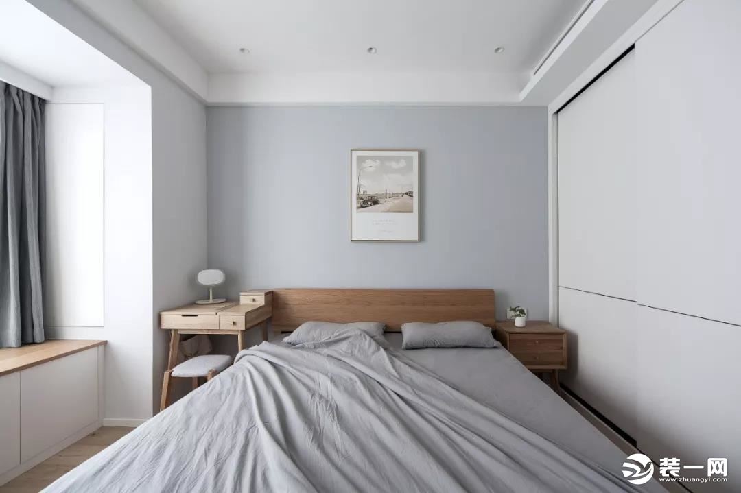 主卧室的床头背景墙和床品是选择了灰蓝色的，给这个简洁的卧室空间，增添了一些北欧风的格调感。用梳妆台来
