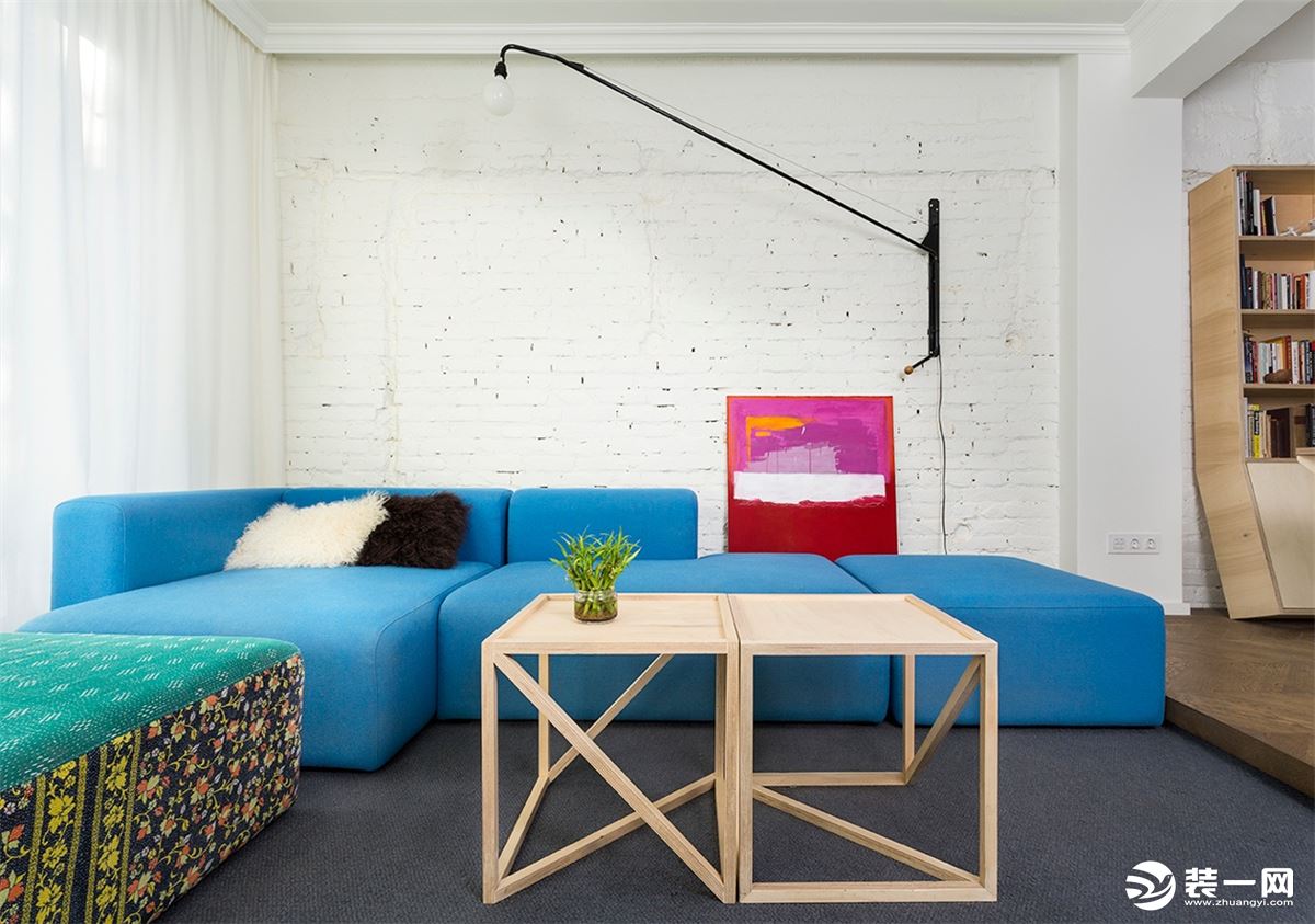 客厅以白色为基础的色调，亮蓝色的沙发，是空间的亮点，沙发分明的线条感，体现风格的特点