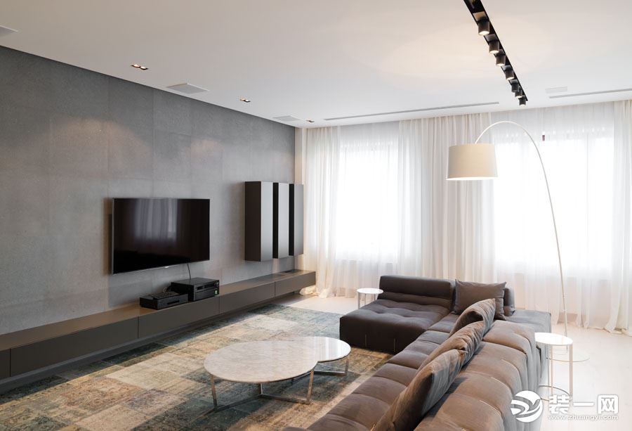 整体的空间以白色为基础色，客厅摆放的深灰色沙发，布艺的材料，柔软舒适，深灰色的电视背景墙与沙发相互呼
