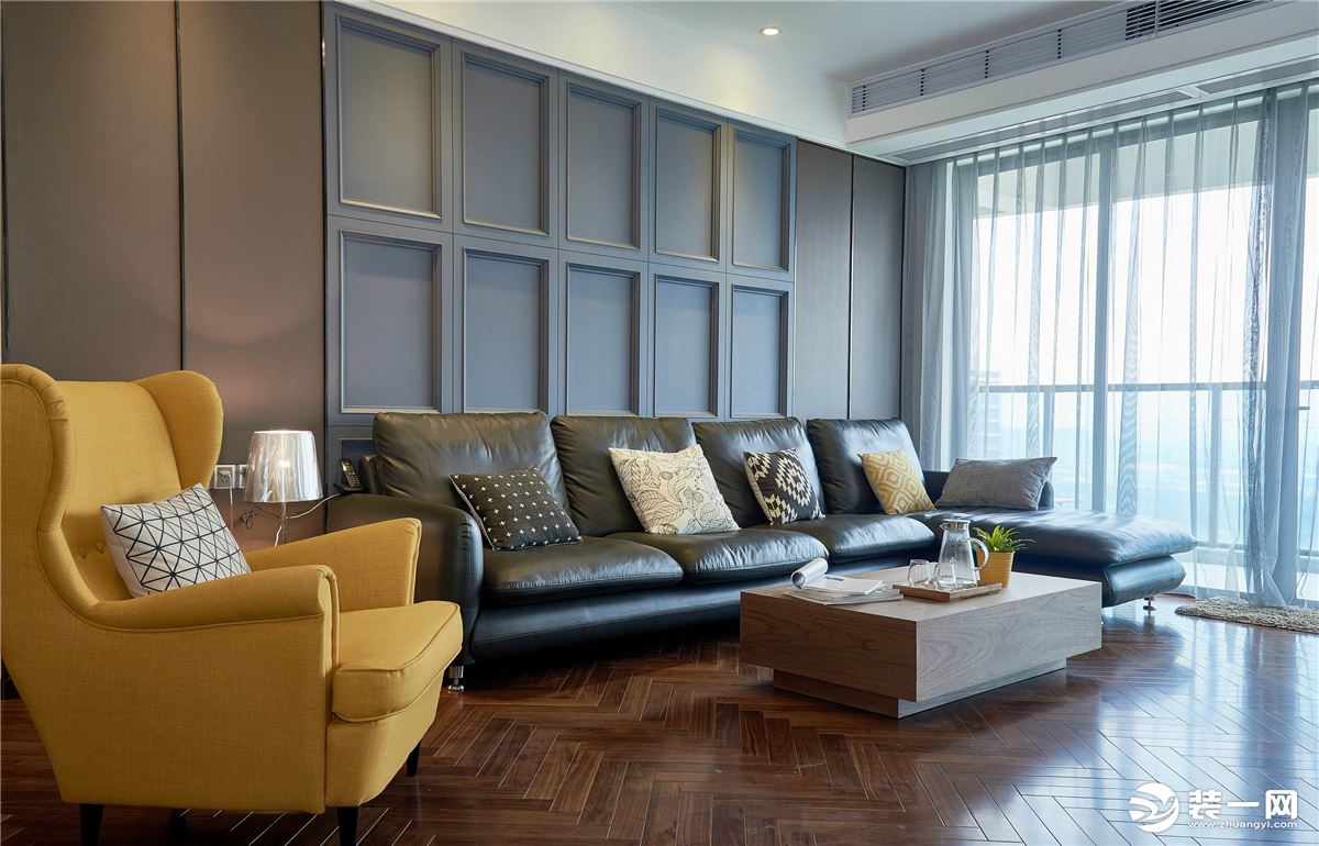 客厅摆放的皮质沙发，搭配原木茶几，沙发背景墙的浮雕设计，展现生活的品质感。