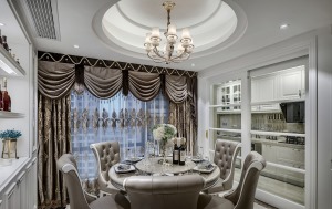 餐厅采用圆桌为主，厚重的窗帘配饰与吊灯的搭展现轻奢的唯美，餐厅与厨房以玻璃滑动门作为隔断，既可以看见