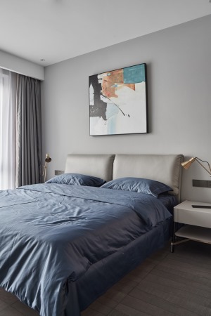 同样的卧室也是以蓝色为点缀，提升空间格调，搭配蓝色床单布置，装扮出一个舒适而又实用的卧室氛围感。