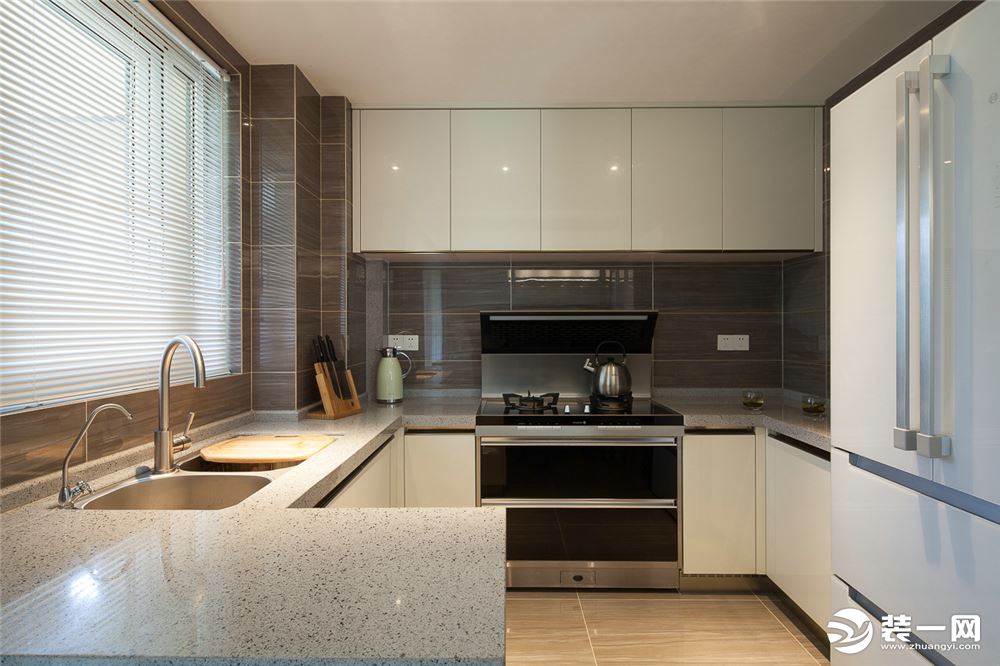 厨房的白色门板搭配白色的石英石台面，整个厨房十分干净整洁。